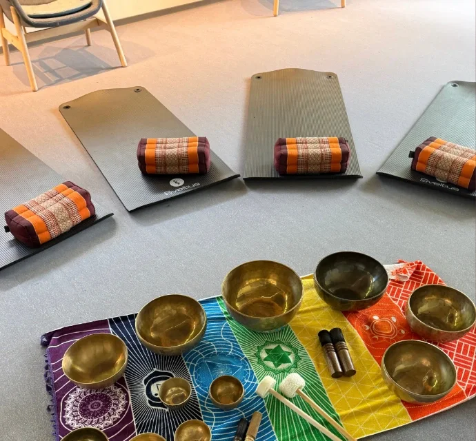 Tapis et coussins installés autour des bols pour un bain sonore collectif