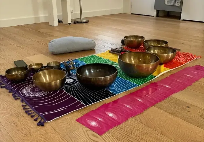 Bols posés sur un tapis aux couleurs des chakras